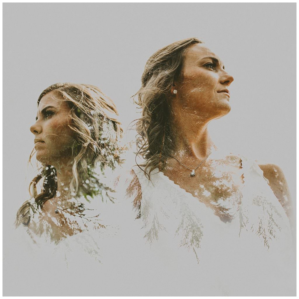 A double exposure of two brides looking opposite directions composited with evergreens.